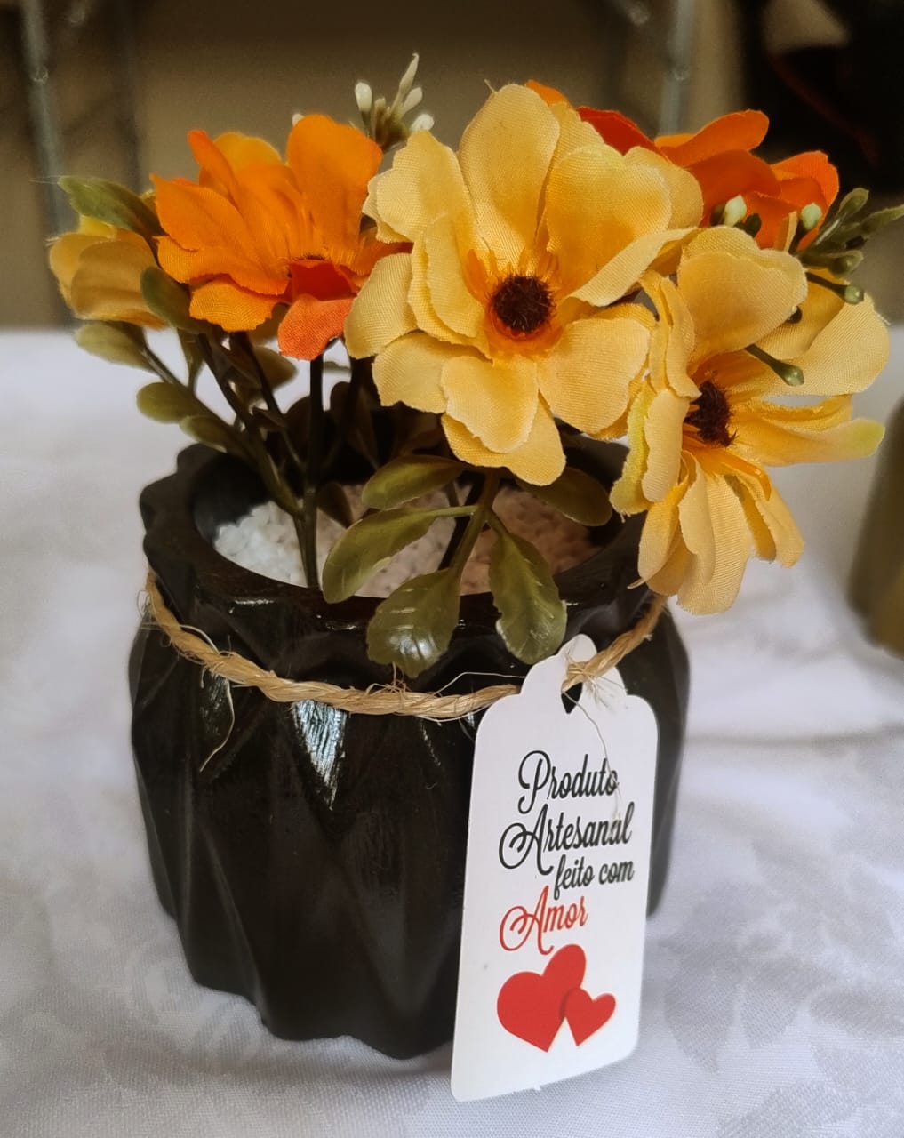 Vaso decorativo artesanal com flores, com etiqueta escrita 'Produto Artesanal feito com Amor'